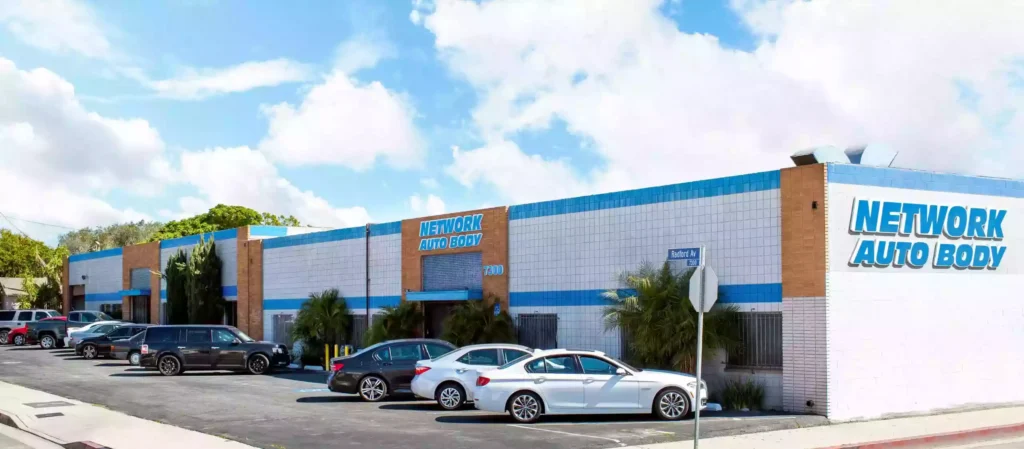 Exterior view of the Network Auto Body North Hollywood location with building signage and customer parking in front.