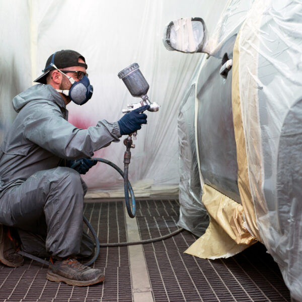 Auto body technician paints car in Los Angeles