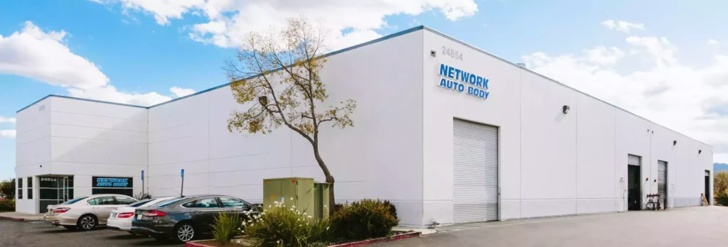 Network Auto Body Valencia collision repair facility at 24854 Avenue Rockefeller with service bays and customer vehicles.