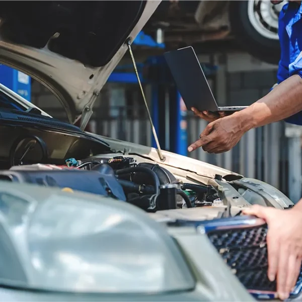 Technician consulting manufacturer repair procedures while inspecting a vehicle.