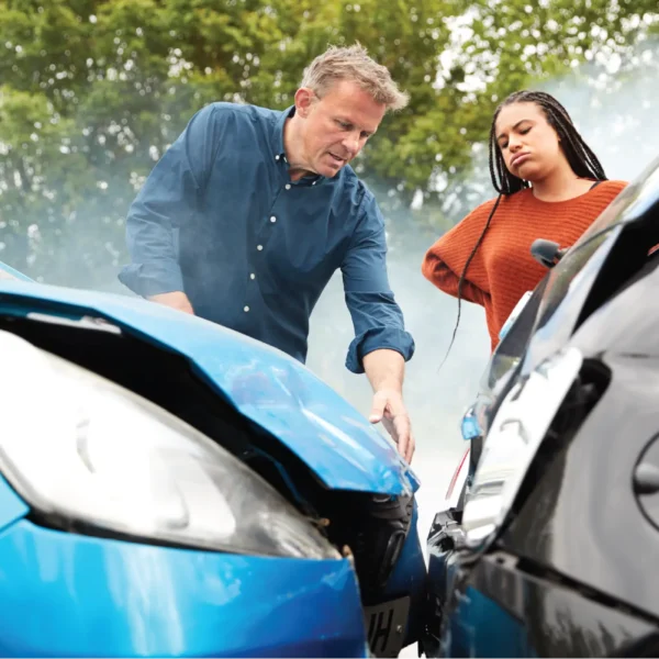 A man and woman inspect their cars after a fender bender.